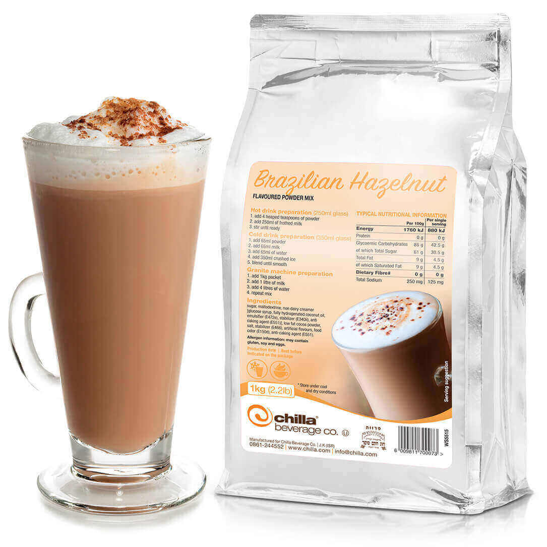 A frothy Brazilian hazelnut latte with cinnamon sits beside a 1kg bag of Chilla Brazilian Hazelnut Powder - Non Dairy, which includes preparation instructions and nutritional details. Both items are featured on a crisp white background.