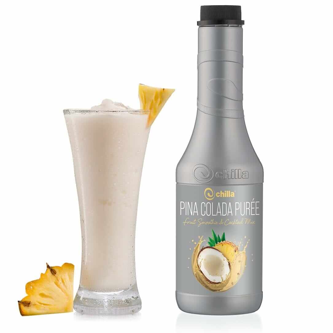 A tall glass of creamy Piña Colada, garnished with a pineapple wedge, sits enticingly beside a 1lt "Chilla Pina Colada Smoothie," featuring coconut and pineapple designs. Ideal for blending into your favorite smoothie on a serene white backdrop.