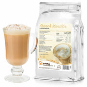 A tall clear glass with a frothy light brown French Vanilla Chilla sits next to a silver package labeled "Chilla Hot French Vanilla Mocca Powder 1kg," showing its nutritional info and branding. Bubbles and specks of powder are visible atop the drink's foam.