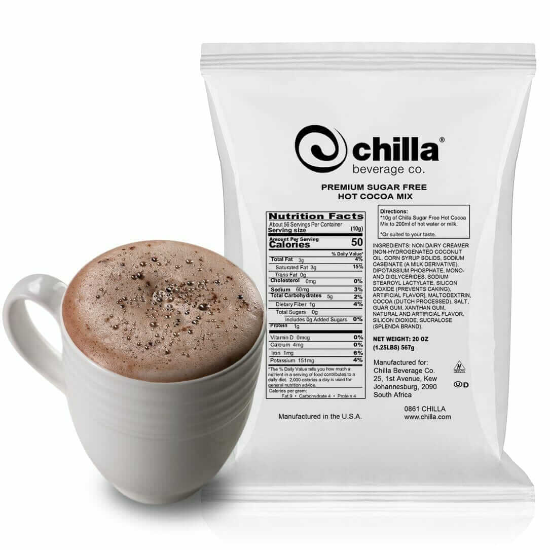 A white cup of frothy hot cocoa topped with chocolate shavings sits next to a Chilla Beverage Co. package labeled "Chilla Sugar FREE Hot Chocolate Powder 1kg," showcasing nutritional facts and ingredients. Made in the USA.